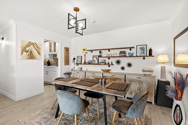 Dining area with an inviting chandelier, crown molding, light wood-style flooring, and baseboards | Image 6