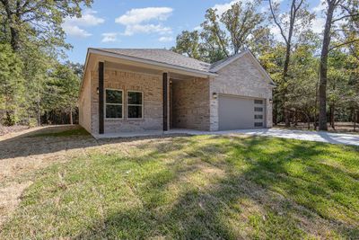 Ranch-style house with a front yard and a garage | Image 2