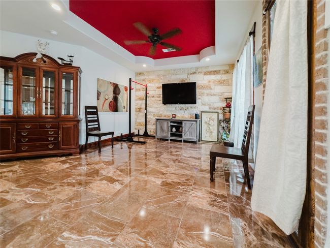 Living room featuring a raised ceiling, marble tiled floors, and ceiling fan | Image 15