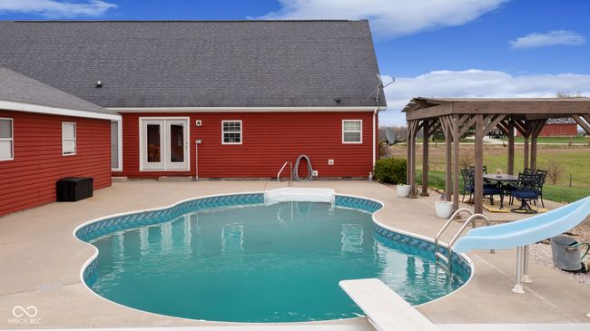 pool with a patio area, french doors, a diving board, and a water slide | Image 46