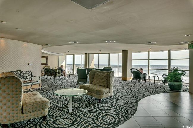 Tiled living room featuring expansive windows and a water view | Image 26