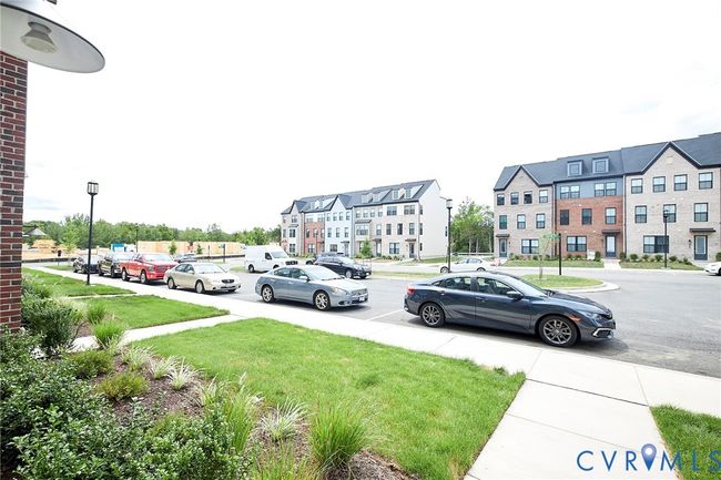 View of asphalt road featuring street lighting, sidewalks, and a residential view | Image 5