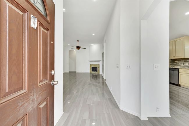 Foyer entrance with ceiling fan and light tile floors | Image 4