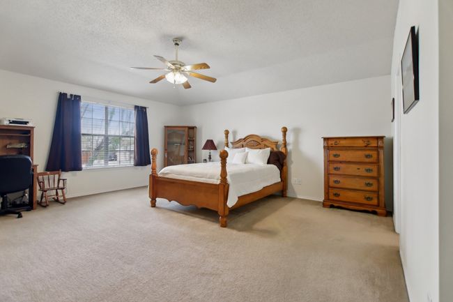 Carpeted bedroom with baseboards, a textured ceiling, and ceiling fan | Image 16