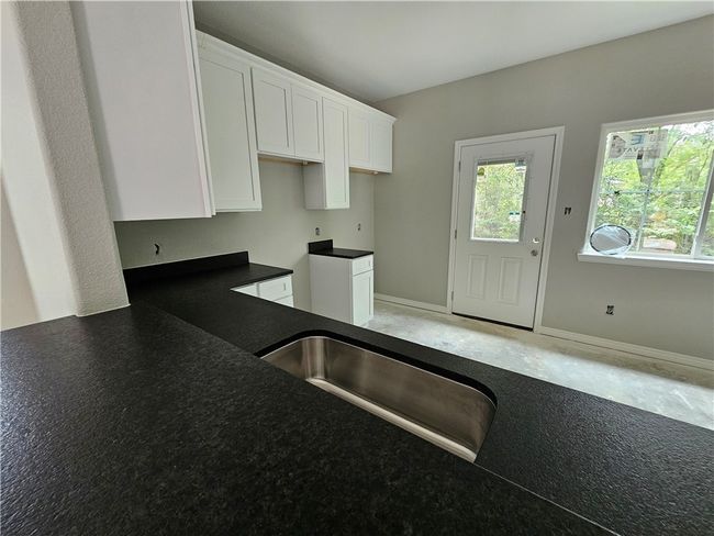 Kitchen with white cabinets and dark countertops | Image 5