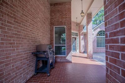 The covered brick front patio & courtyard area perfect for outdoor dining and entertaining. | Image 3