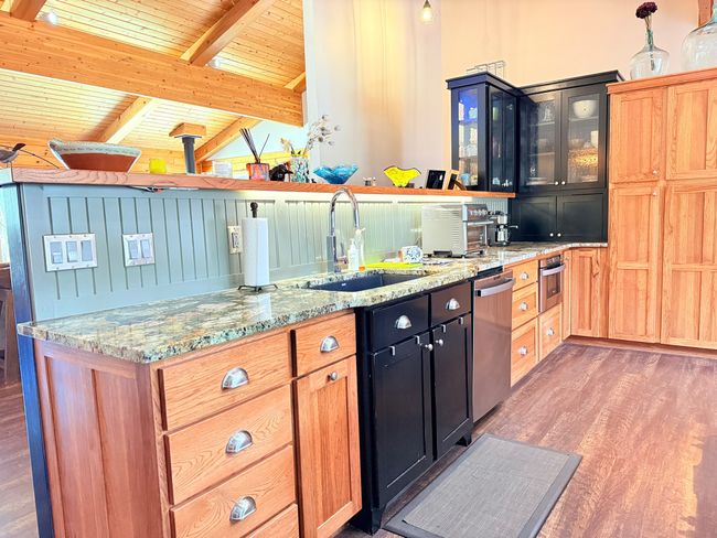 Kitchen with granite countertops, wood floors, an undermount soapstone sink, and newer dishwasher | Image 11