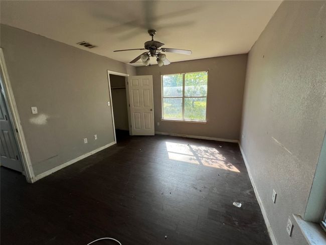 Unfurnished bedroom with baseboards, a walk in closet, a ceiling fan, and a closet | Image 17