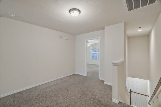 Empty room with a textured ceiling, visible vents, baseboards, and light carpet | Image 14