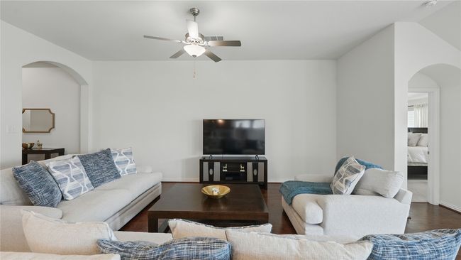 Living room featuring arched walkways, a ceiling fan, and wood finished floors | Image 5