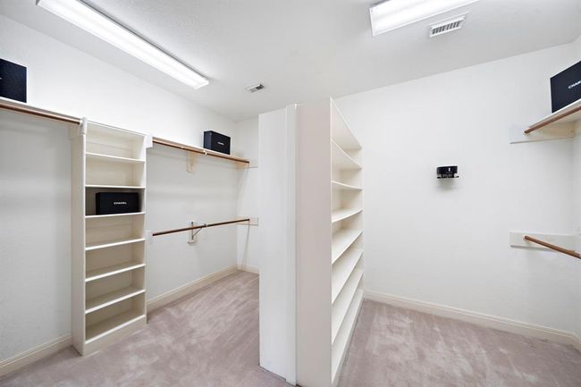 The primary bedroom's walk-in closet features built-in shelves and racks, providing a sophisticated solution for maintaining organization. | Image 27