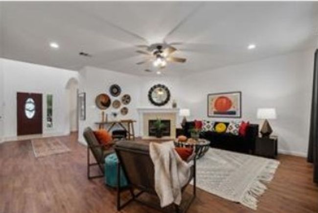 Living area with a fireplace, wood finished floors, a ceiling fan, and baseboards | Image 13
