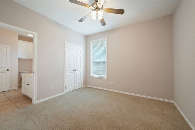 Unfurnished bedroom featuring light carpet, baseboards, ensuite bath, and a closet | Image 16