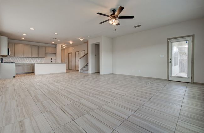 Unfurnished living room featuring ceiling fan, stairs, recessed lighting, and light tile patterned floors | Image 15