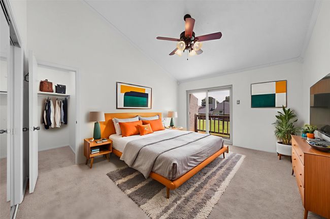 Virtually staged. Upstairs primary bedroom with two closets, ceiling fan, ensuite bath and balcony overlooking greenbelt. Beautiful sliding glass doors and carpet has been replaced. | Image 13