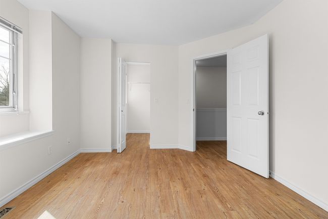 Unfurnished bedroom featuring a spacious closet, a closet, light wood finished floors, and baseboards | Image 24