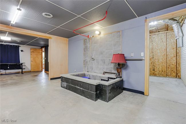 Bathroom featuring concrete flooring and a bath | Image 41