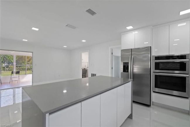 Kitchen featuring white cabinetry, modern cabinets, visible vents, and stainless steel appliances | Image 8