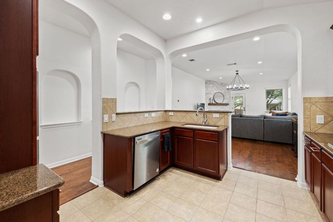 Kitchen with dishwasher, open floor plan, decorative backsplash, stone counters, and recessed lighting | Image 12
