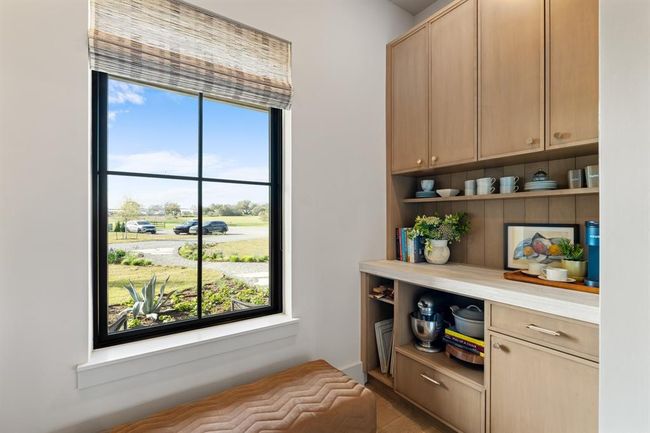 The second end of the pantry features a counter space with a place for a microwave. Should you require a second sink or second dishwasher, there is plumbing in the wall to accommodate that need in the future. | Image 13
