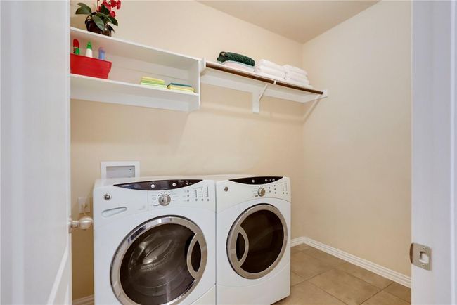 Washroom featuring washer and dryer, baseboards, and light tile patterned floors | Image 8