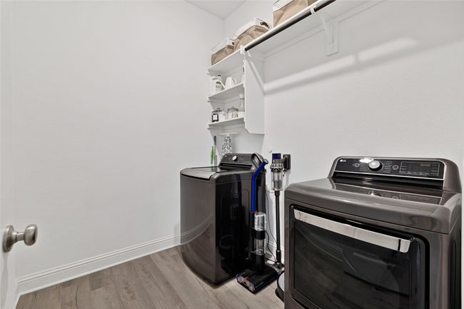 Laundry room with light wood-style floors, independent washer and dryer, and baseboards | Image 19
