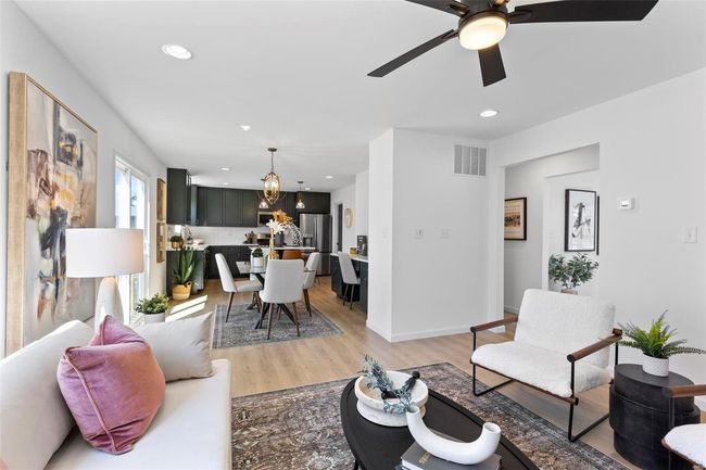 Living room featuring ceiling fan with notable chandelier and light wood-type flooring | Image 17