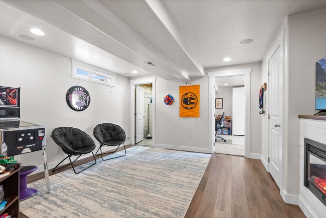 Fully finished basement featuring a family room with wood-look vinyl floors, recessed lighting, and electric fireplace | Image 27