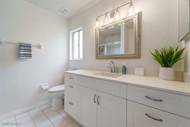 Full bathroom with vanity, tile patterned flooring, visible vents, toilet, and baseboards | Image 5