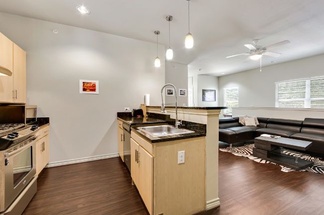 Kitchen with a peninsula, stainless steel appliances, dark wood-type flooring, open floor plan, and a ceiling fan | Image 15