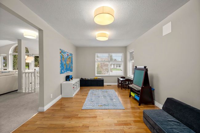Sitting room featuring light wood-style flooring, baseboards, and a textured ceiling | Image 19