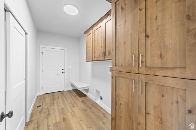 Interior space with hookup for an electric dryer, light wood-style floors, visible vents, cabinet space, and washer hookup | Image 18
