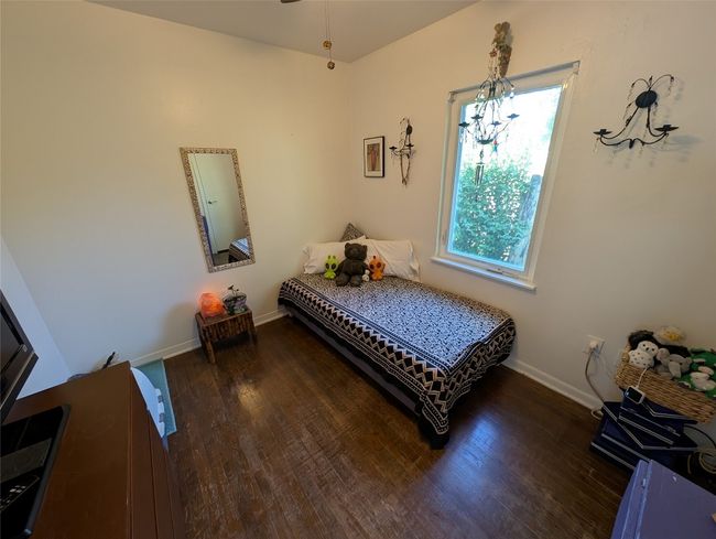 Bedroom featuring baseboards, a chandelier, and wood finished floors | Image 17
