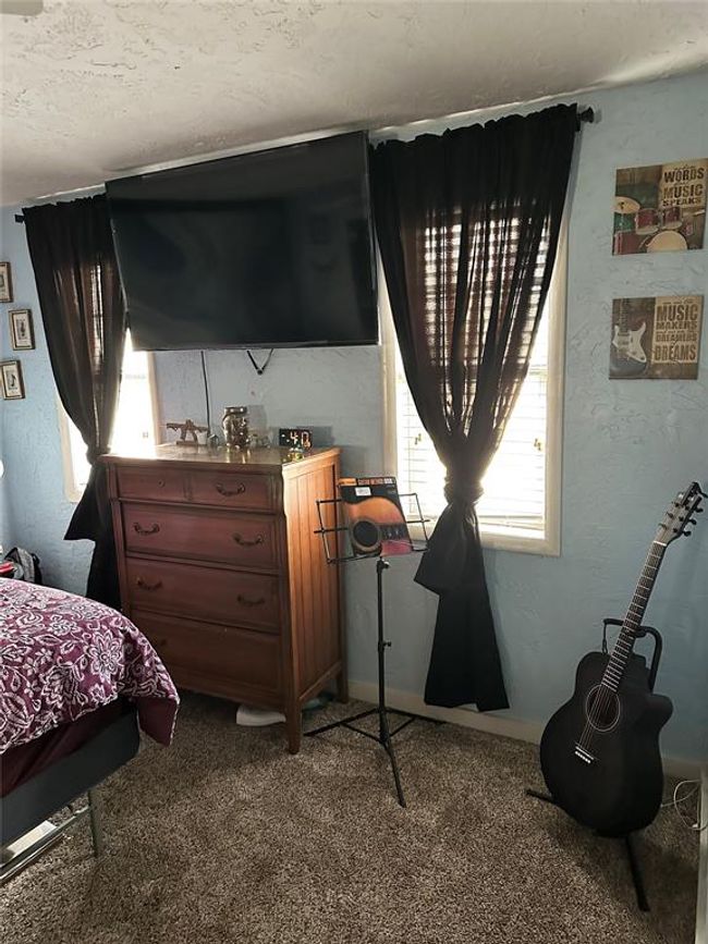 Carpeted bedroom with a textured wall | Image 18