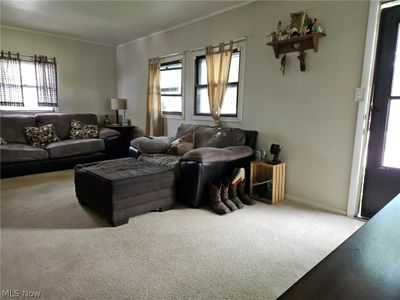 Carpeted living room featuring ornamental molding and plenty of natural light | Image 2