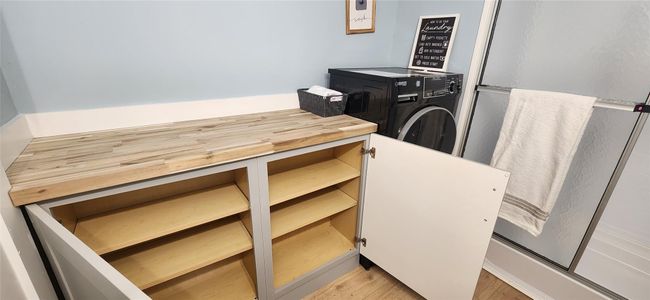 Laundry room with light wood-style floors and washer / dryer | Image 21