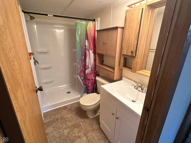 full bath featuring toilet, vanity, and a shower stall | Image 37