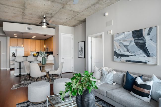 Living area with a ceiling fan and dark wood-style floors | Image 5