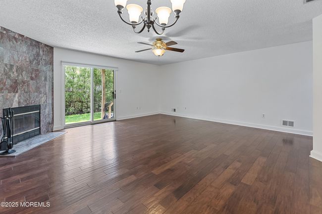 Spacious, open Living - Dining Room opens to rear patio. Cozy fireplace provides ambiance and warmth on chilly nights. | Image 6