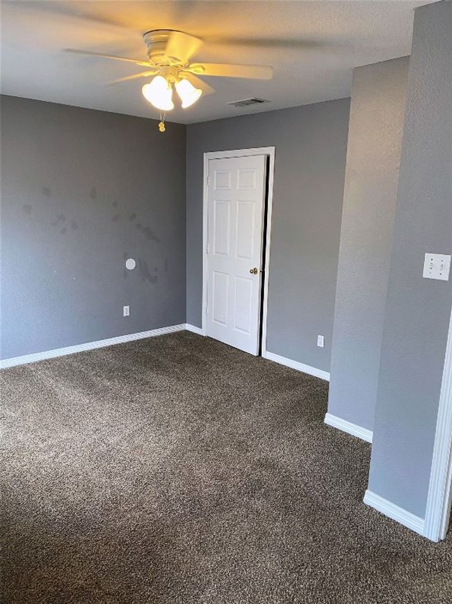 Unfurnished room with baseboards, ceiling fan, visible vents, and dark carpet | Image 15