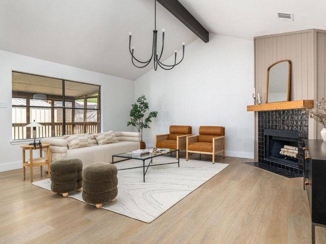 Living area with a tiled fireplace, visible vents, baseboards, beamed ceiling, and light wood-style floors | Image 10