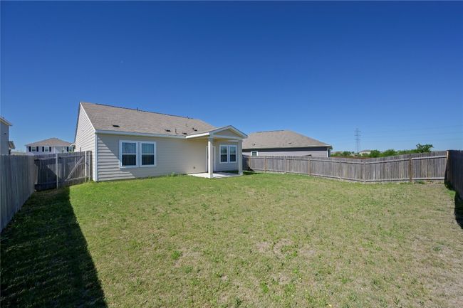 Rear view of house with a fenced backyard and a lawn | Image 37