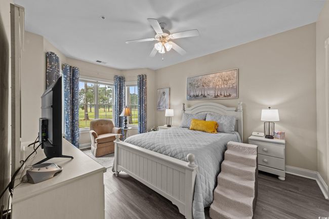 Bedroom with dark wood-type flooring, baseboards, and ceiling fan | Image 8