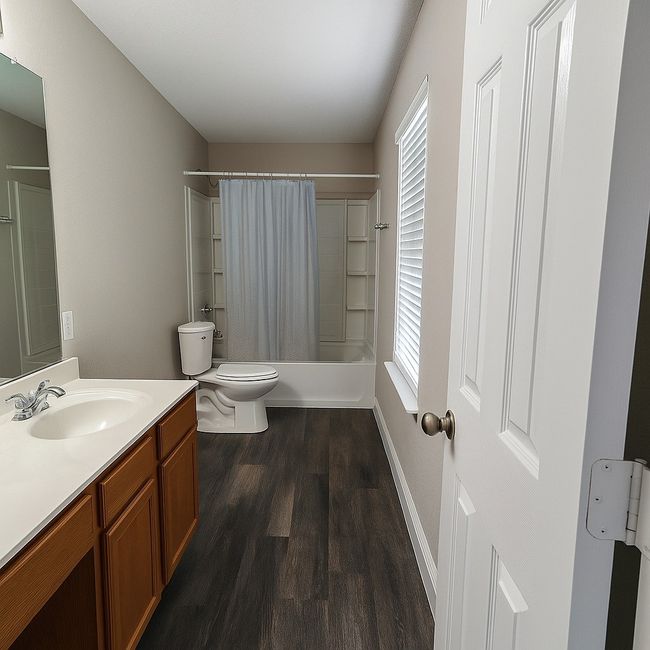 Full bathroom with vanity, wood finished floors, shower / bath combination with curtain, and healthy amount of natural light | Image 15