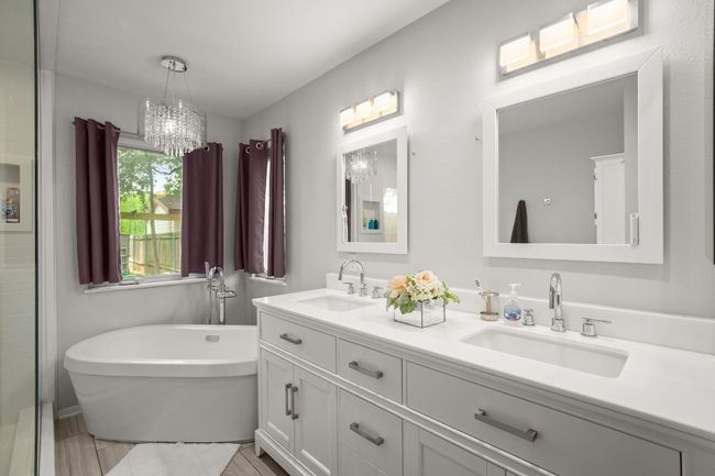 The ensuite bath feels like a personal spa, featuring a freestanding soaking tub beneath a chandelier and a spacious walk-in shower with a rainfall showerhead for a truly luxurious experience | Image 18