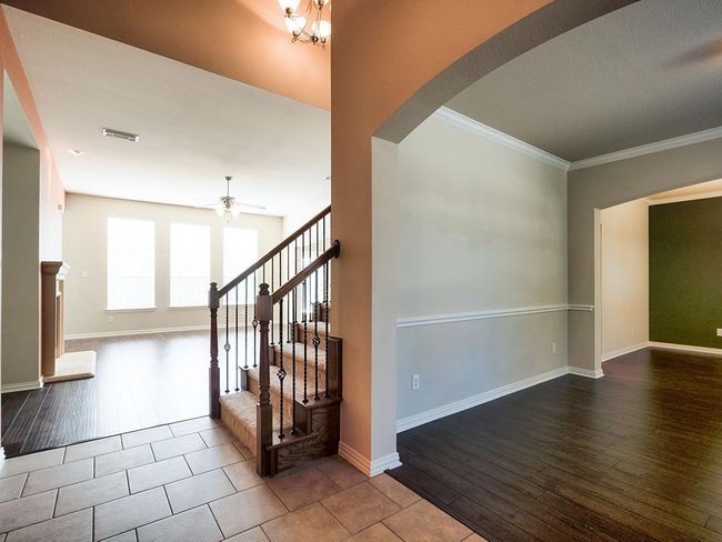 Staircase with wood finished floors, arched walkways, ceiling fan, crown molding, and baseboards | Image 6
