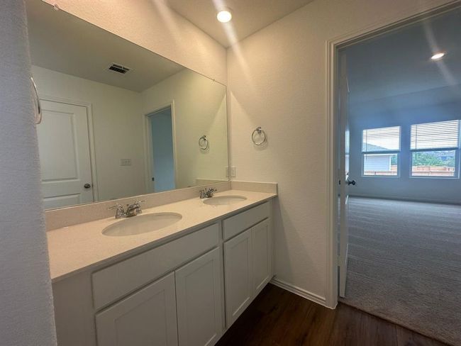 Bathroom featuring double vanity, wood finished floors, baseboards, and a textured wall | Image 22