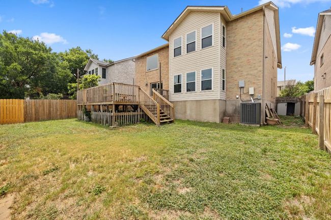 Rear view of property with stairway, central AC unit, a deck, and brick siding | Image 39