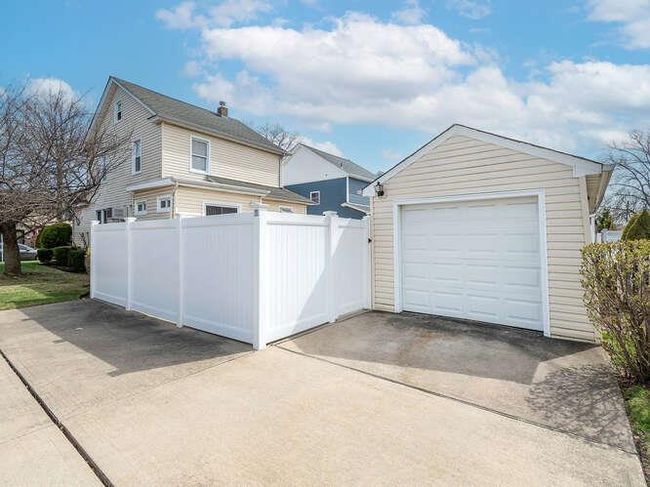 Detached garage with concrete driveway and fence | Image 12