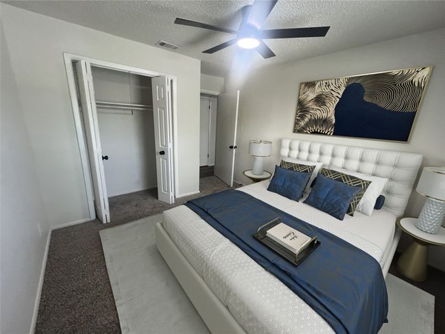Bedroom featuring visible vents, a textured ceiling, carpet flooring, and a closet | Image 6